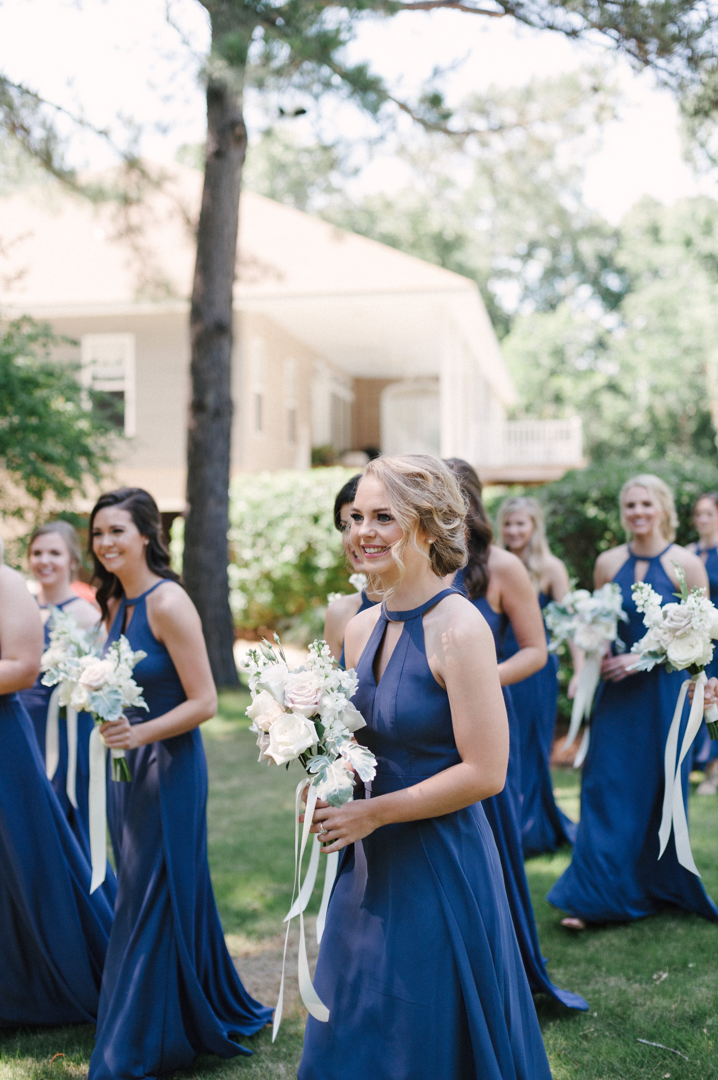 Pretty bridesmaid with an updo hairstyle walking with other bridesmaids at a residence in Montgomery, AL