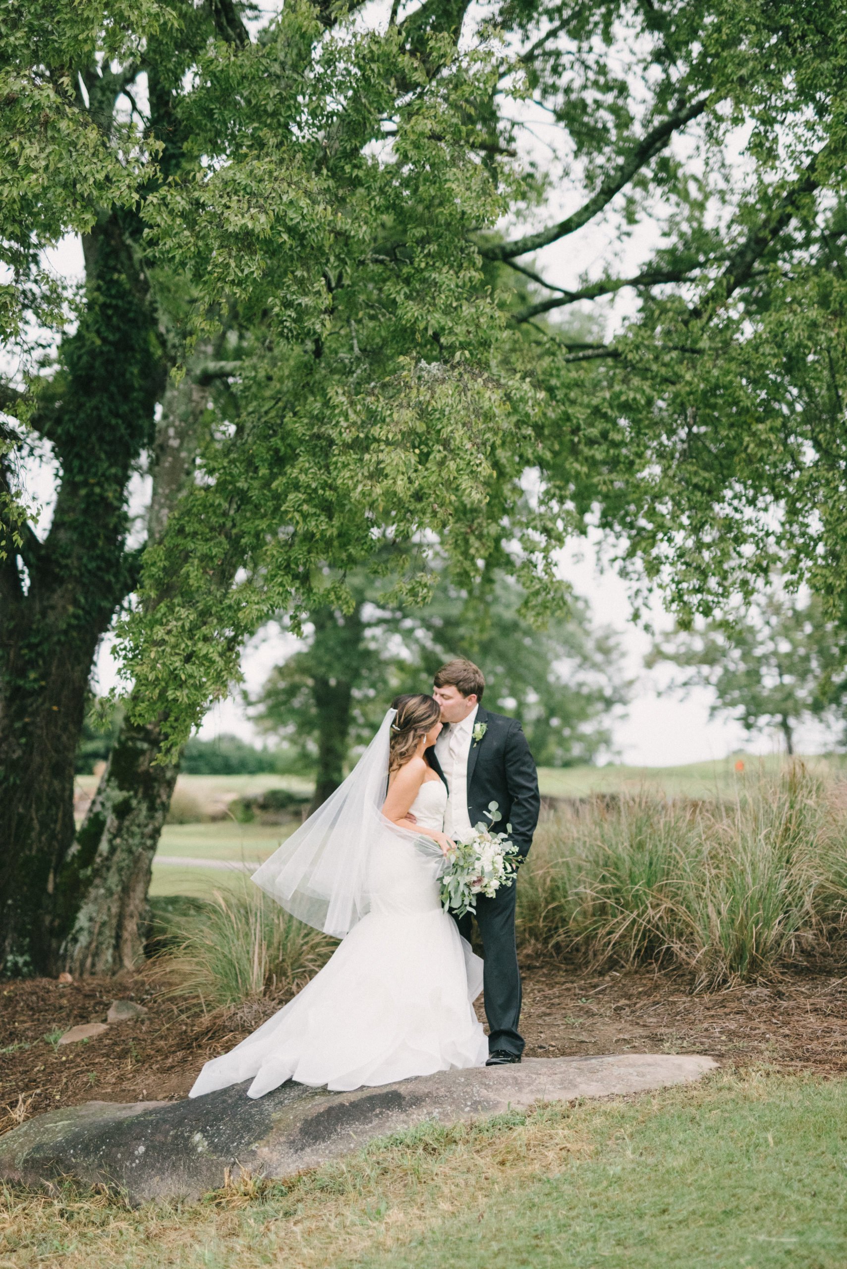Vestavia Hills groom kissing bride outdoors by Olivia Joy Photography