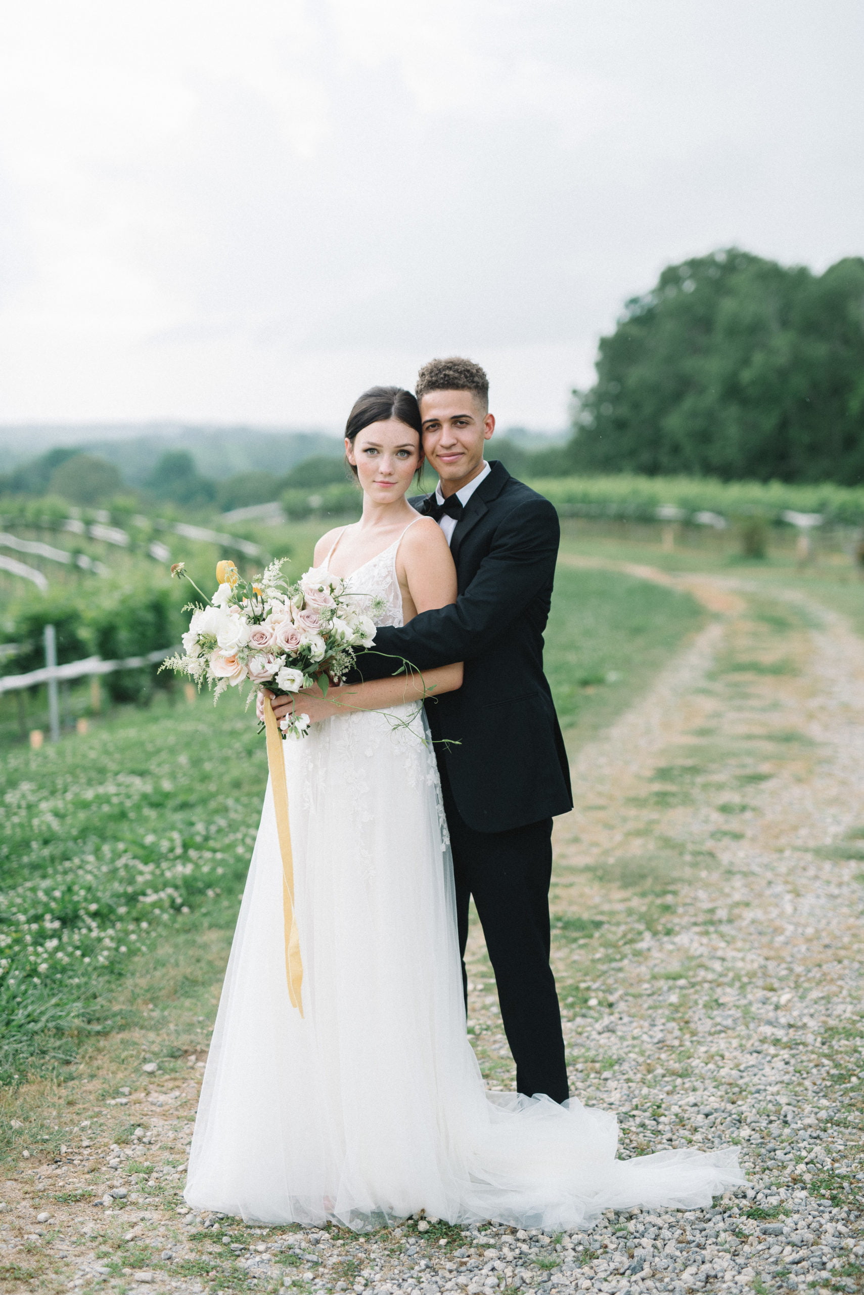 Beautiful wedding couple posing for photographer at vineyard in GA