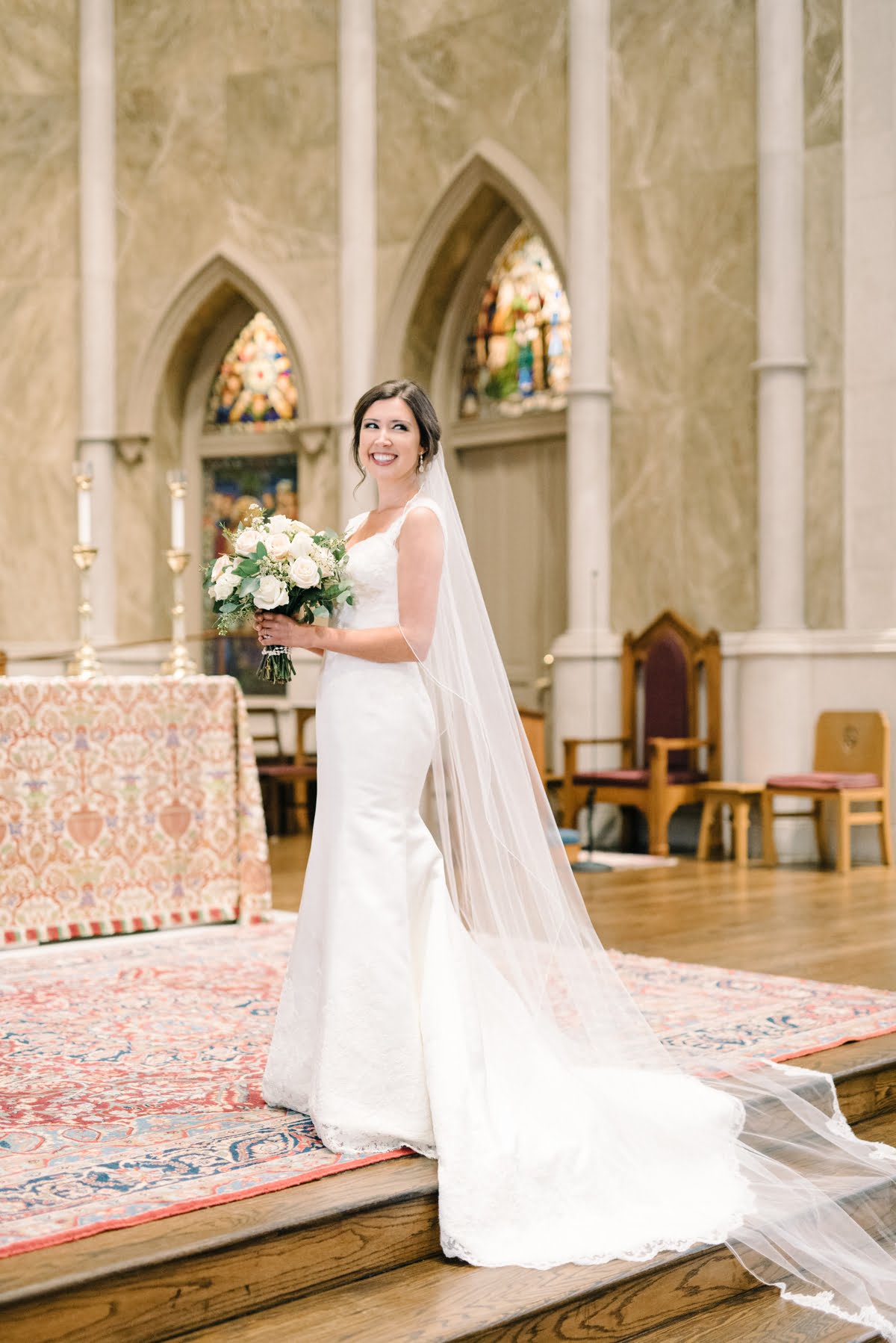 Stunning bride on her wedding day inside Cathedral of St Paul's smiling to the side for her portraits in Birmingham