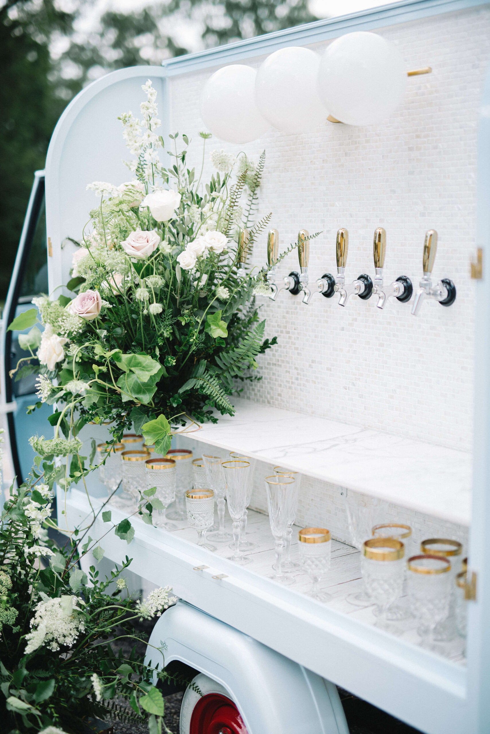 Wedding floral arrangements on a cute and quaint beverage truck with golden goblets by Tippy Tap Co. | Pursell Farms in Sylacauga, AL