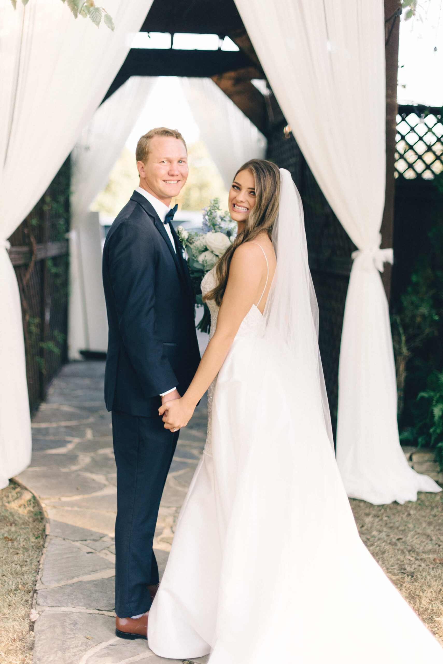 A wedding couple super happy and smiling at the camera immediately after they recessed down the aisle of their ceremony after vows and their kiss at Park Crest Events wedding venue
