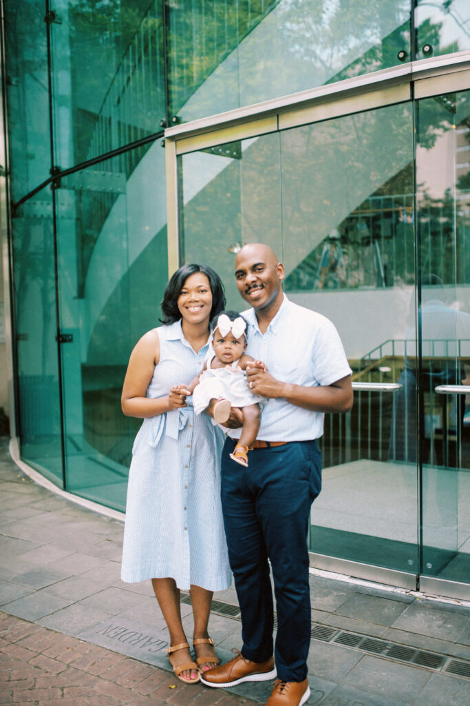 A beautiful happy family portrait photo in front of the glass doors at Birmingham Art Museum in Alabama