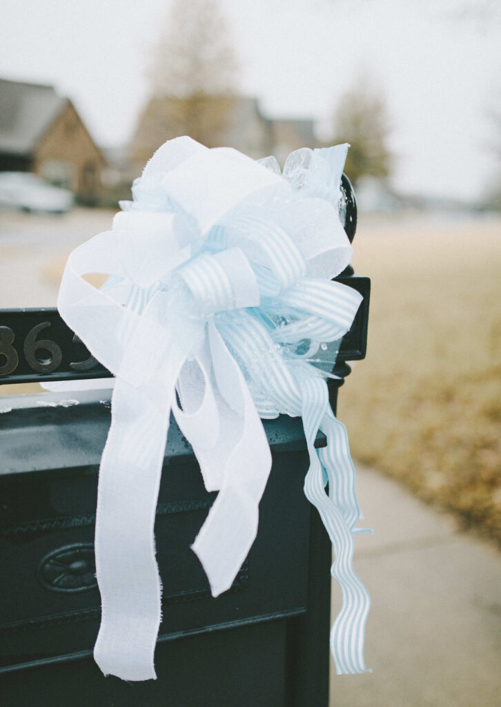 Welcome home baby blue ribbon bow on mailbox outside